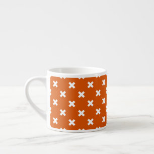 White cross stitches on burnt orange espresso cup