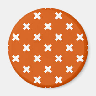 White cross stitches on burnt orange magnet