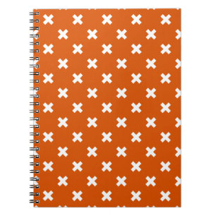 White cross stitches on burnt orange notebook