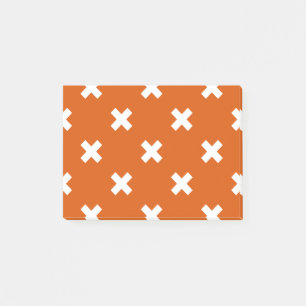 White cross stitches on burnt orange post-it notes