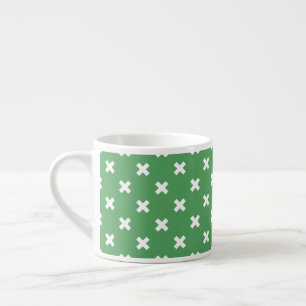 White cross stitches on green espresso cup