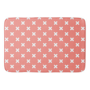 White cross stitches on peach bath mat