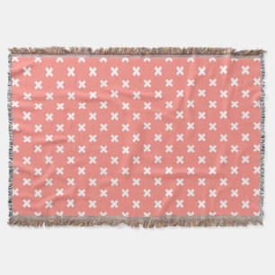 White cross stitches on peach throw blanket