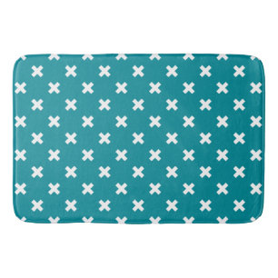 White cross stitches on teal bath mat