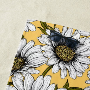 White daisies, wild flowers on yellow beach towel