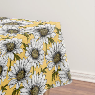 White daisies, wild flowers on yellow tablecloth