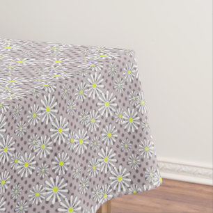 White daisy flowers on a beige brown polka dot tablecloth