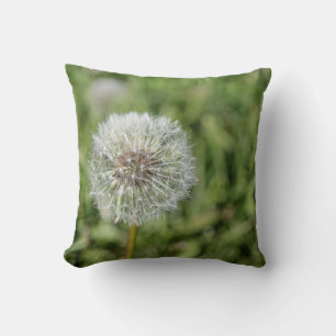 White dandelion flower on green grass throw pillow