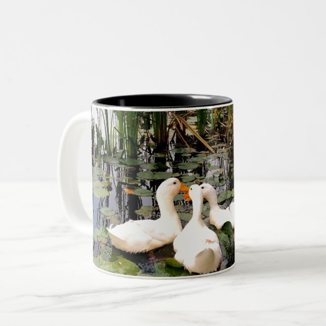 White ducks, lily pads, cattails, lake shore Two-Tone coffee mug (Front Left)