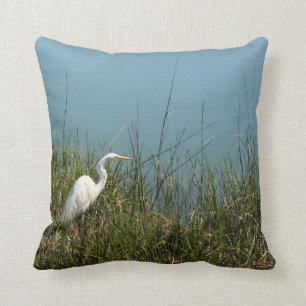 White egret standing in grass w water throw pillow