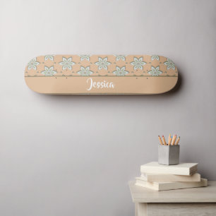 White engraved flowers on tan skateboard