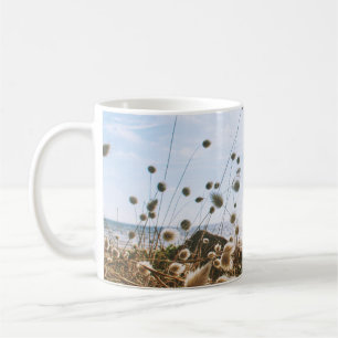 WHITE FLOWERS FIELD NEAR BODY OF WATER UNDER BLUE  COFFEE MUG