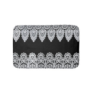 White lace forms a delicate border against black bath mat