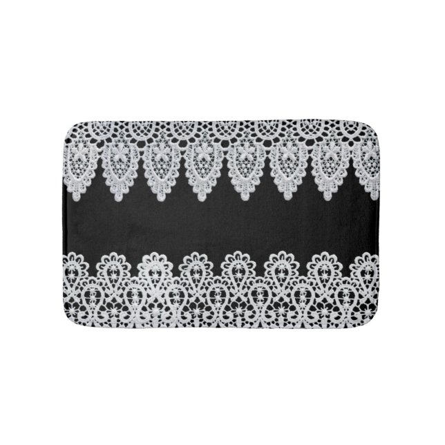 White lace forms a delicate border against black bath mat (Front)