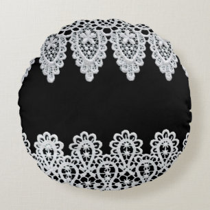 White lace forms a delicate border against black round pillow