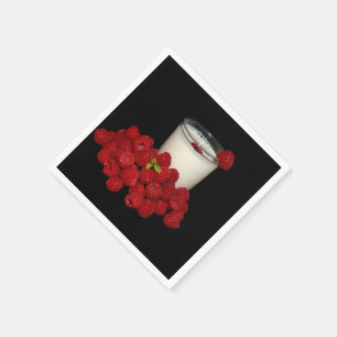 white milk with red raspberries on a black napkin