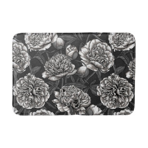 White peony flowers on dark grey bath mat