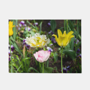 White, pink and yellow tulips in the garden doormat