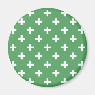 White polka crosses on green magnet