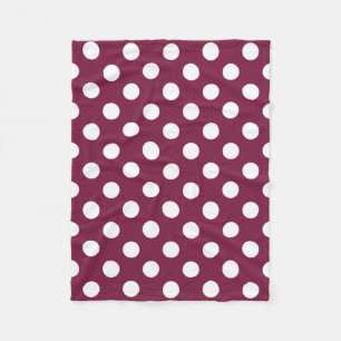 White polka dots on burgundy fleece blanket