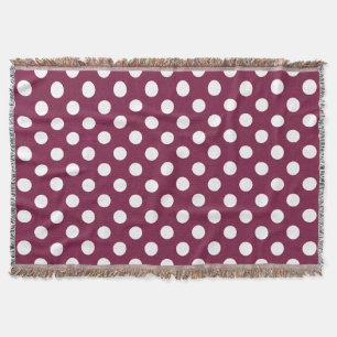 White polka dots on burgundy throw blanket