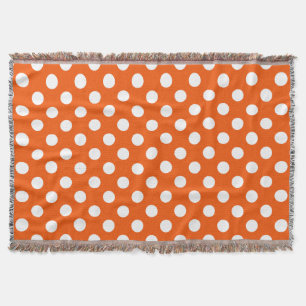 White polka dots on orange throw blanket