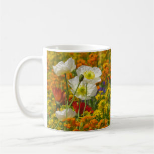 White poppies growing around the colourful flowers coffee mug
