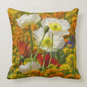 White poppies growing around the colourful flowers throw pillow