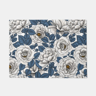 White roses with blue leaves on white doormat