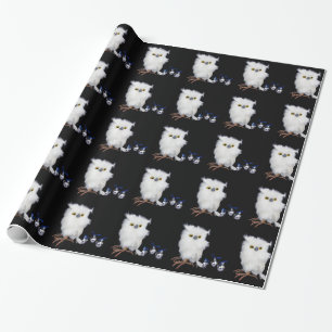 White snowy owl figurine with silver christmas wrapping paper