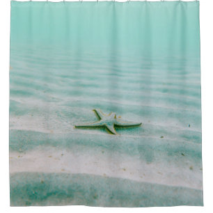White starfish on sand underwater in the morning