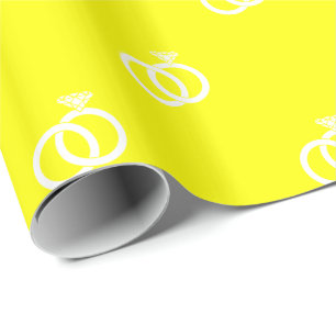 White Wedding Rings on Yellow Wrapping Paper