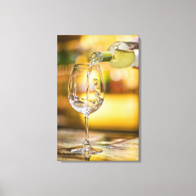 White wine is poured from bottle in restaurant. canvas print (Front)