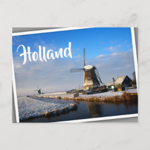 Windmill in the snow in a dutch winter landscape postcard