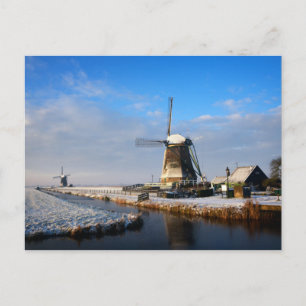 Windmill in the snow in a dutch winter landscape postcard