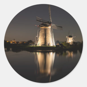 Windmills illuminated at night round sticker