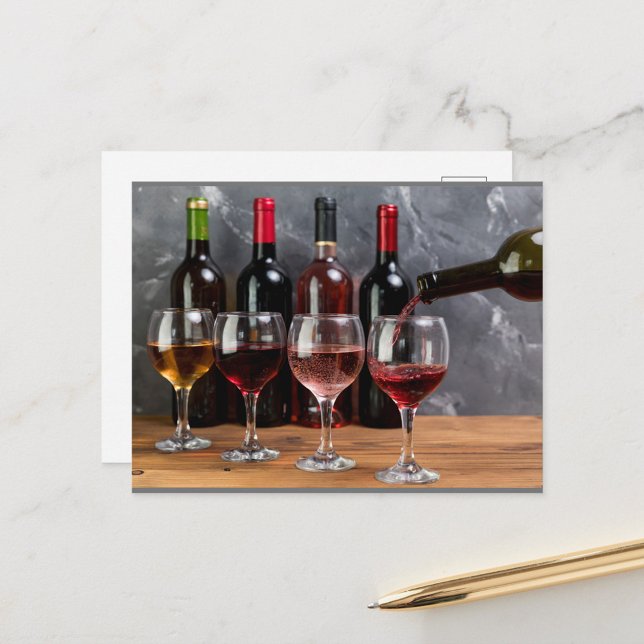 Wine Bottles Postcard (A hand pours red wine into a glass, with a row of wine bottles in the background!)