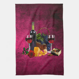 Wine glasses, bottle, grapes, cheese, chacolates kitchen towel