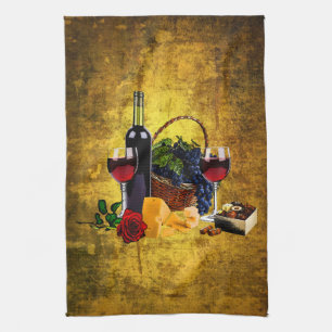 Wine glasses, bottle, grapes, cheese, chacolates kitchen towel