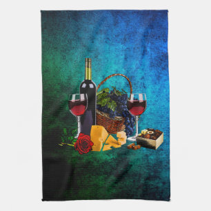Wine glasses, bottle, grapes, cheese, chocolates kitchen towel