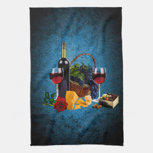 Wine glasses, bottle, grapes, cheese, chocolates kitchen towel