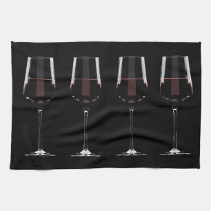 Wine glasses with red wine on black kitchen towel
