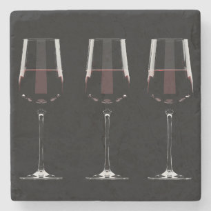 Wine glasses with red wine on black stone coaster