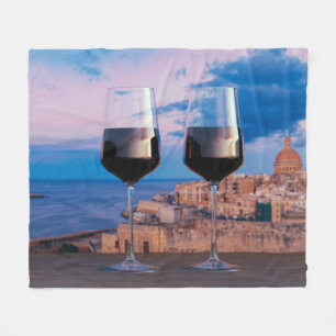 Wine glasses with view of sunset over Valletta Fleece Blanket