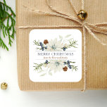 Winter Floral Watercolor Merry Christmas Square Sticker<br><div class="desc">This personalized holiday sticker features a watercolor bouquet of white poinsettias flecked with gold and winter greenery, including brown pine cones and dusty blue berries. In the middle, the words "Merry Christmas" appear in dusty blue serif font on a white background. Personalize the design with your family name below in...</div>