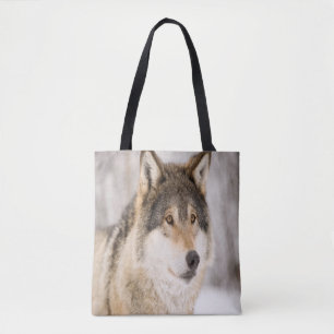 Wolf smiling in snow and winter forest tote bag