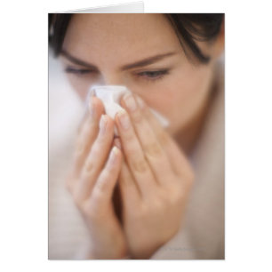 Woman blowing her nose.