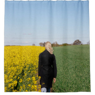 Woman in black coat standing on green grass field 
