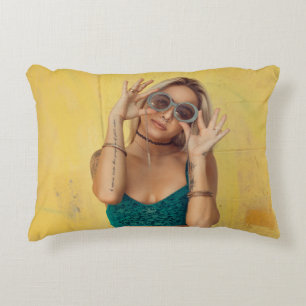 Woman in blue bralette holding sunglasses putting  accent pillow