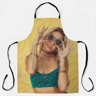 Woman in blue bralette holding sunglasses putting apron